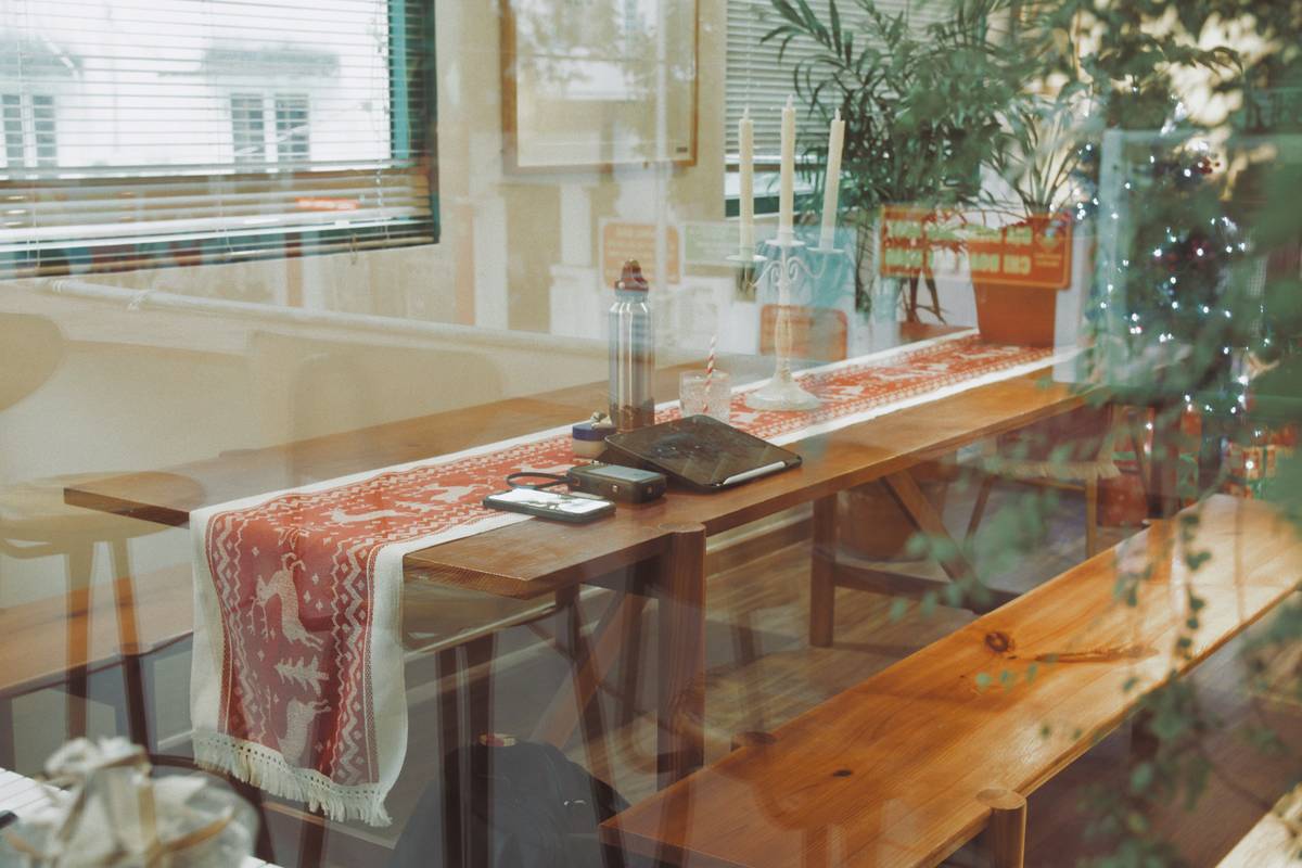 Neutral-toned farmhouse style table runner on wooden dining table with vintage stoneware